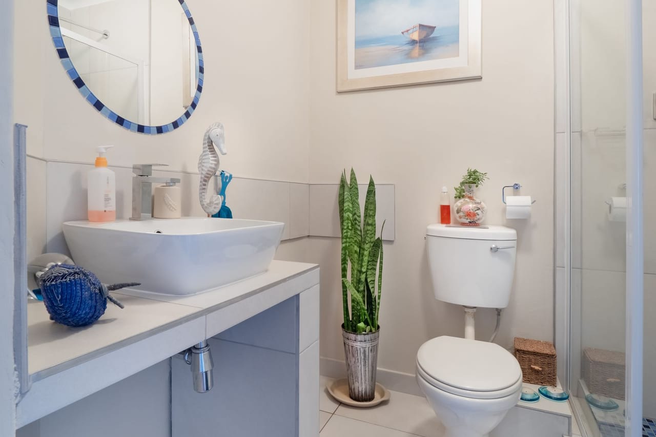 Toilet flushes weakly: White ceramic toilet bowl beside glass wall