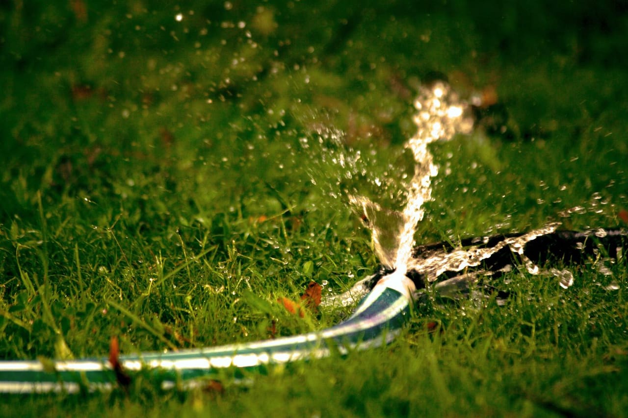 Washing machine hose burst: Close up photography of water bursting out of hose