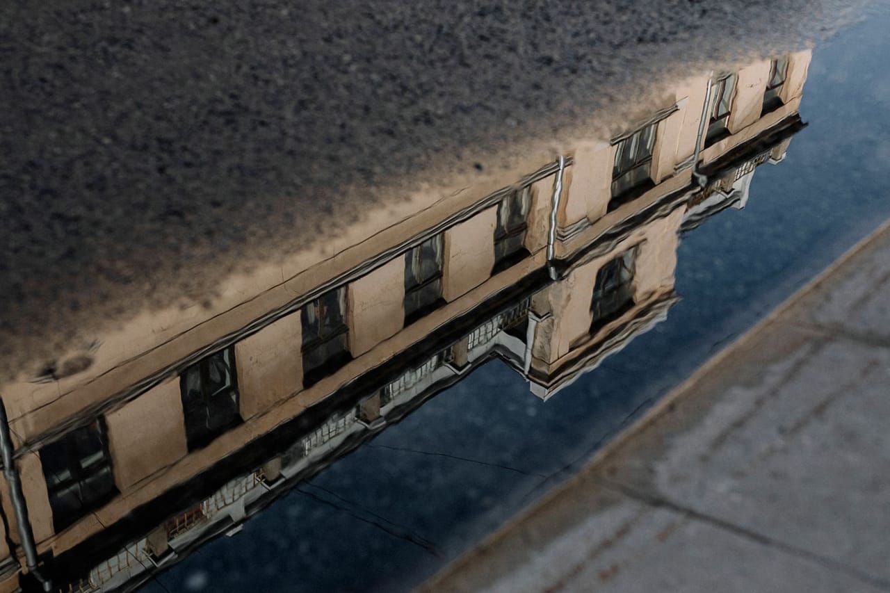 Water in crawl space: A building reflected in a street puddle