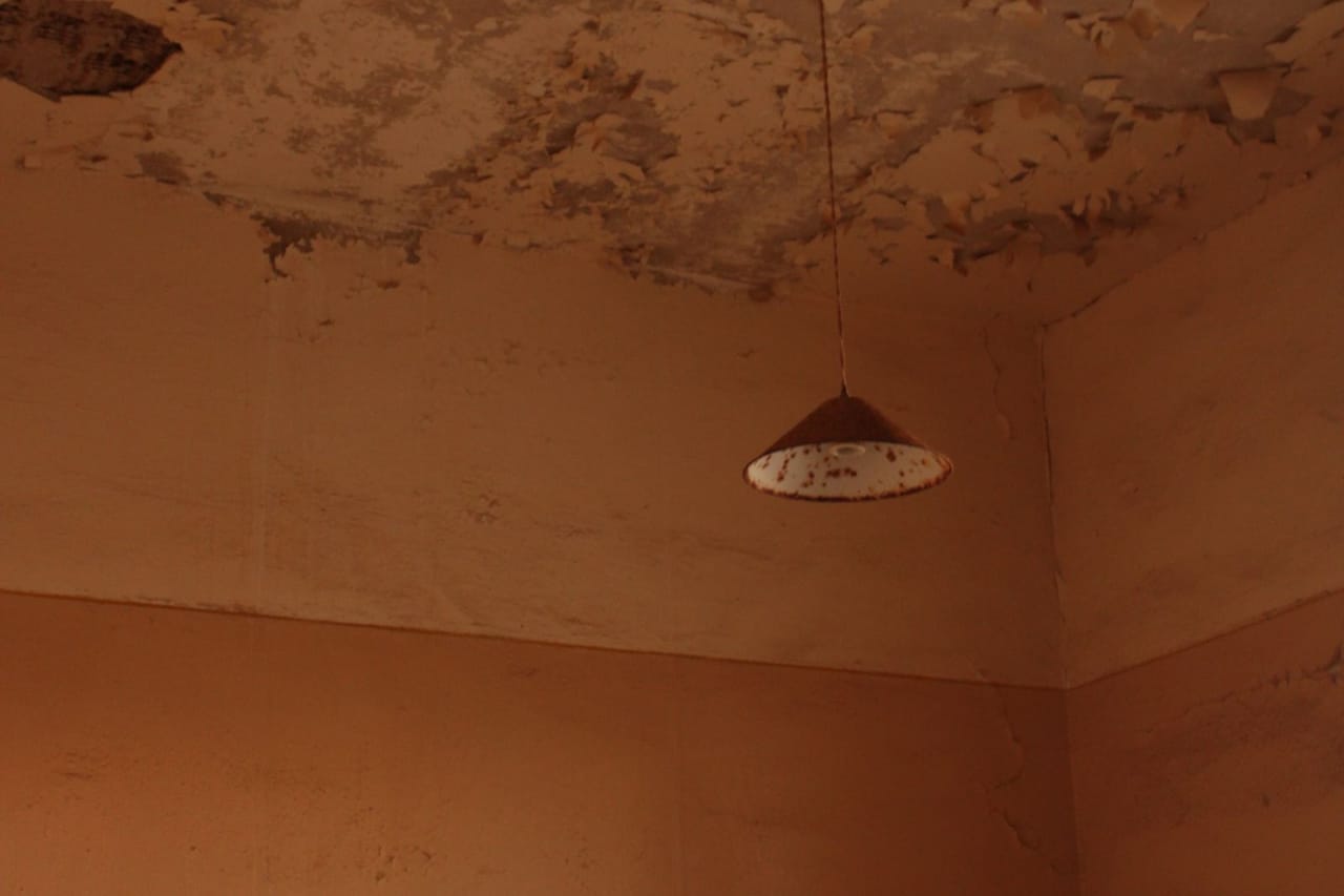 Water stain on ceiling: Lamp on damaged ceiling in room corner
