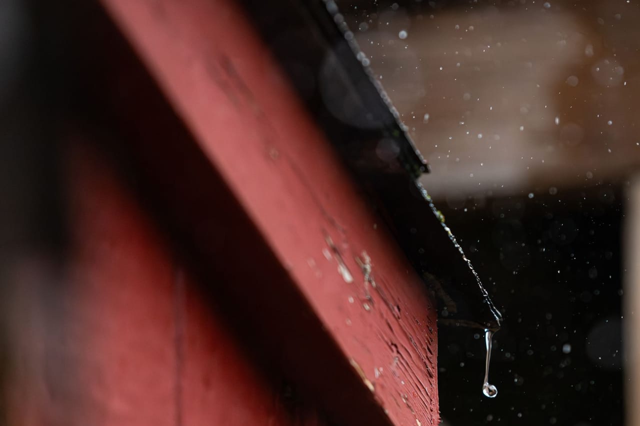 What is drip edge on a roof: Close up of a droplet on a red roof edge