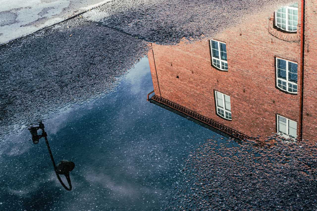 What to do about a flooded basement: Reflection of brick building in puddle landscape
