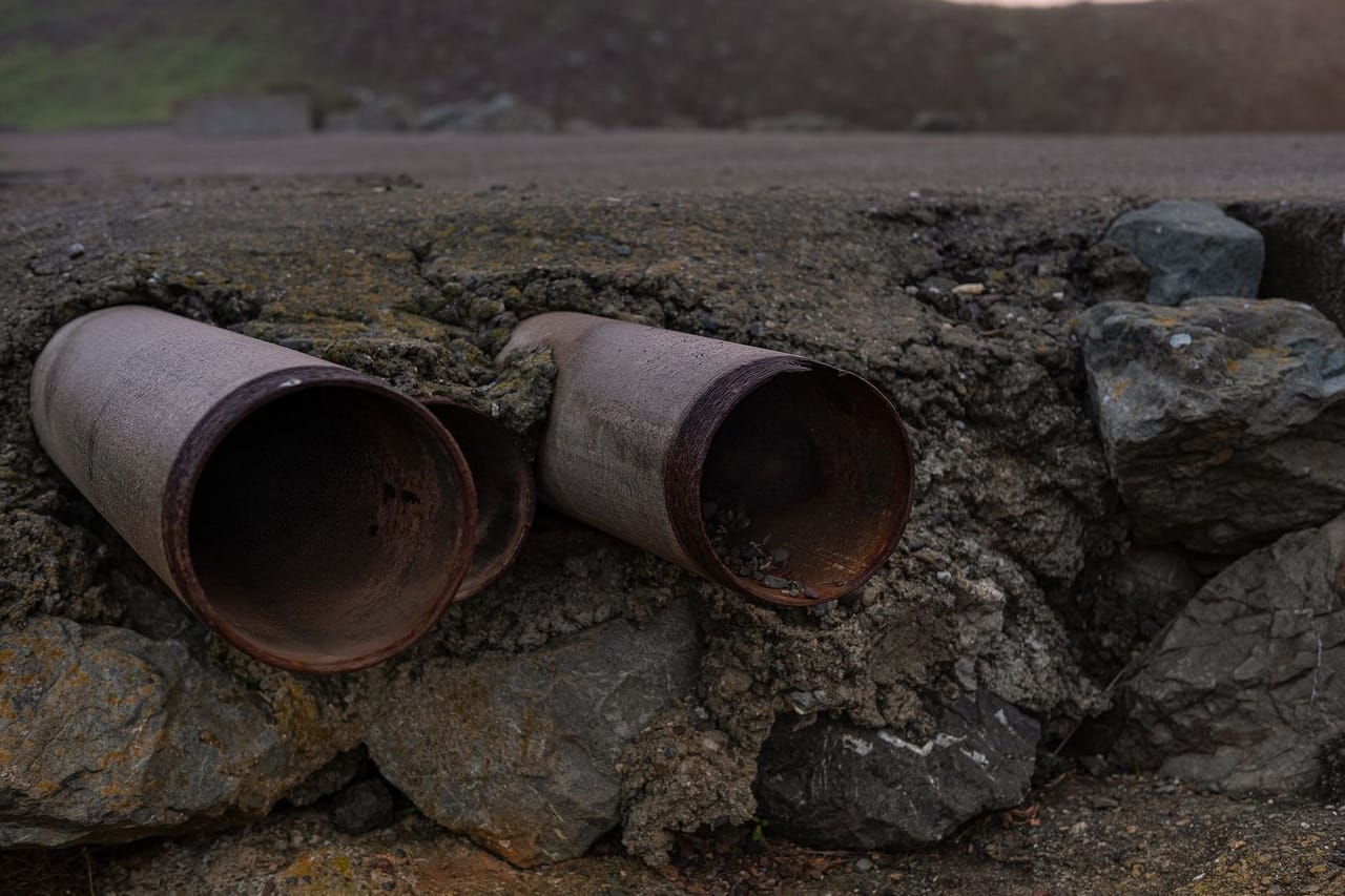 Plumber Brownwood TX: Steel pipes near rocky edge of the road