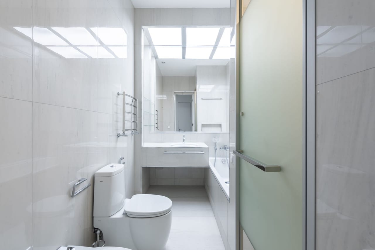 Plumber Crawfordsville IN: Bathroom with white ceramic toilet bowl in a white wall tile