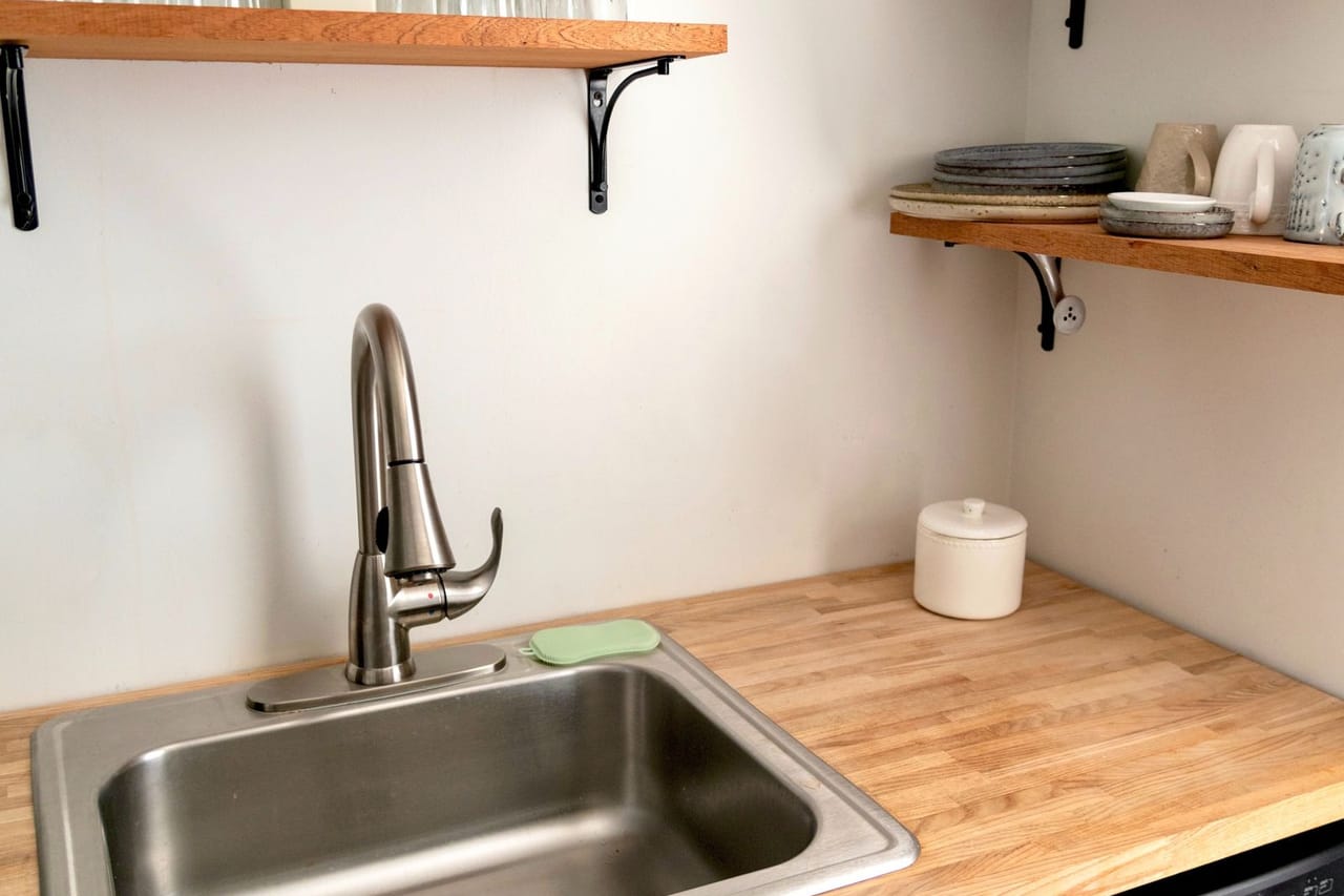 Plumber Jackson MS: Stainless steel sink with faucet on wooden kitchen counter
