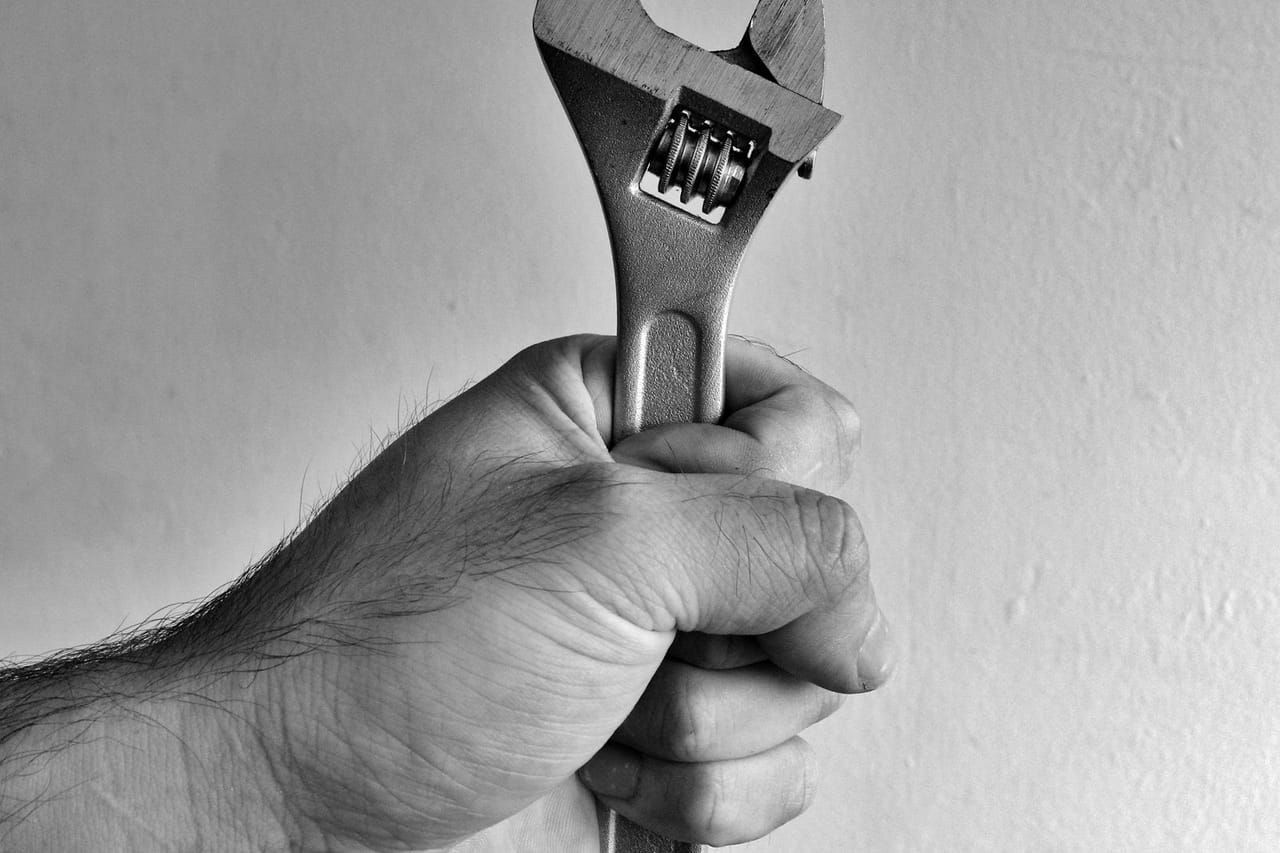 Plumber Jacksonville FL: Black and white hand holding adjustable wrench