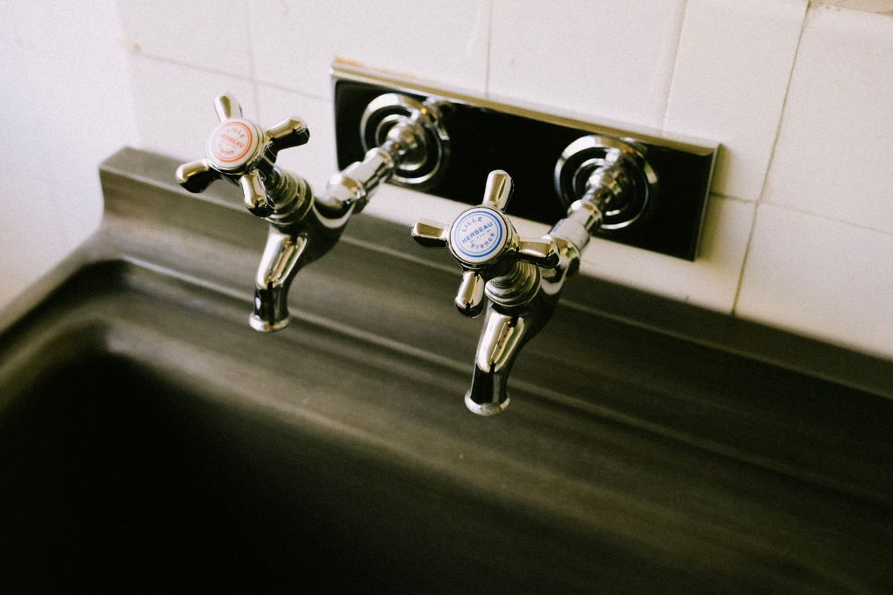 Plumber Mckinney TX: Close up shot of two silver faucets in the sink