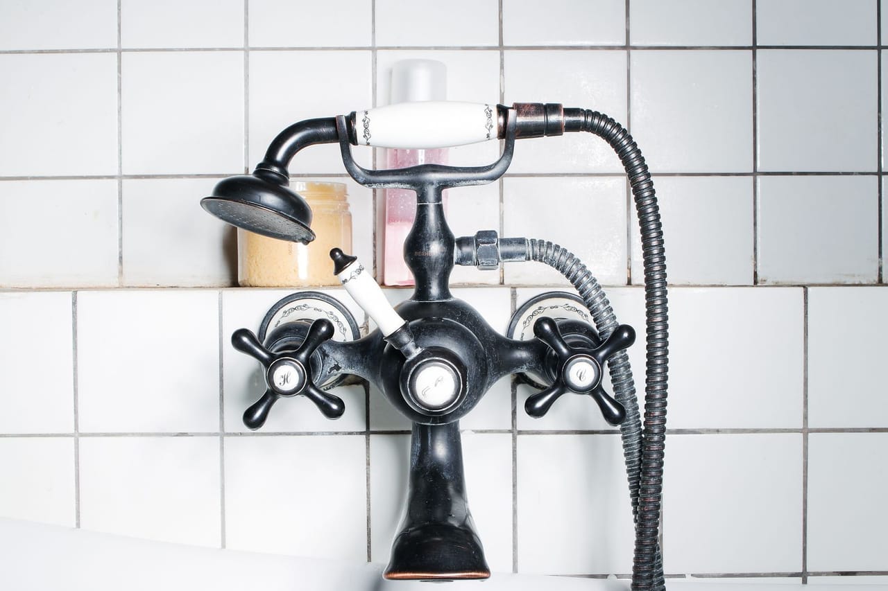Plumber Pittsburgh PA: Black faucet on white wall tiles