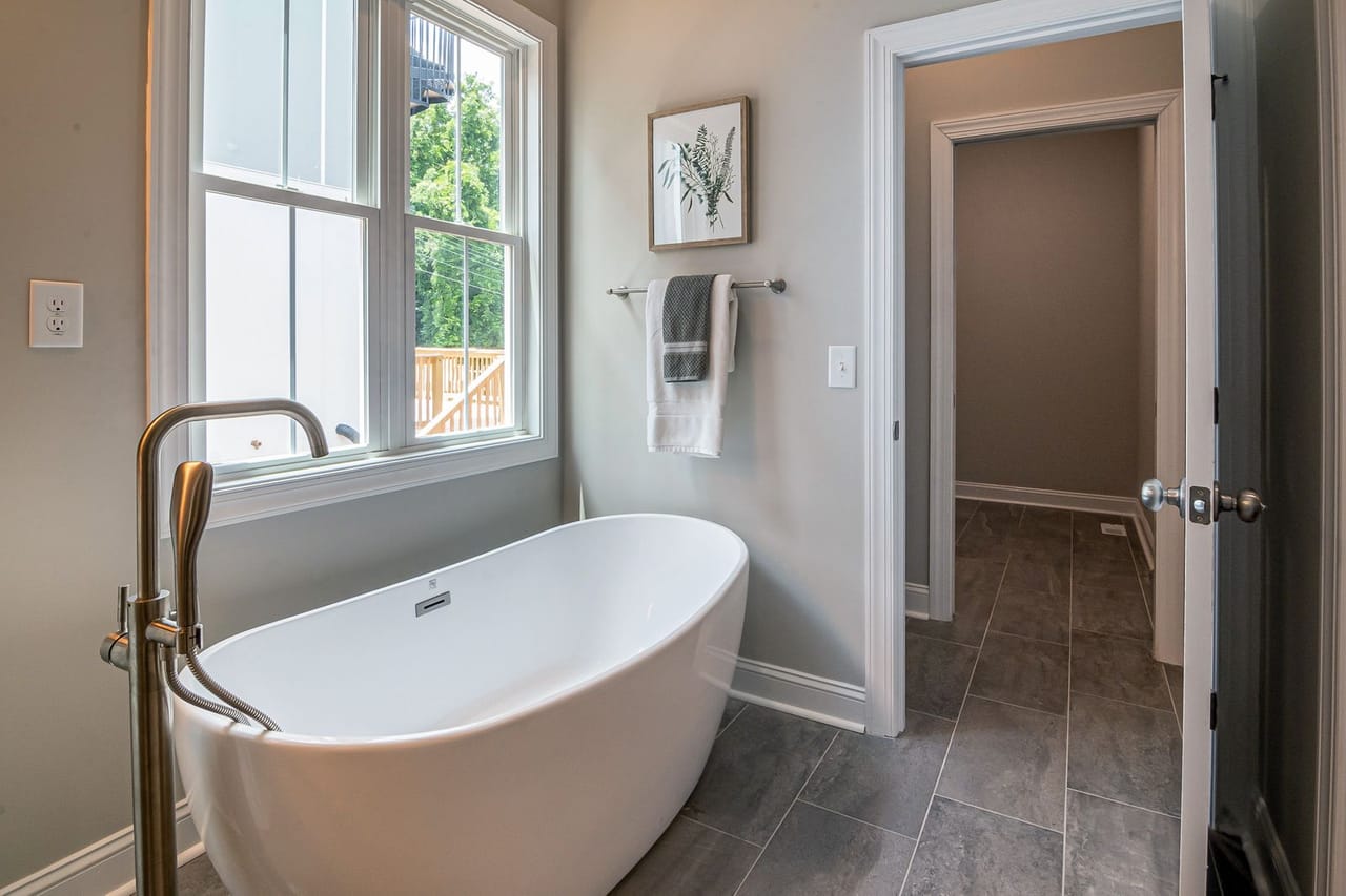 Plumber Plano TX: White bathtub near white framed glass window