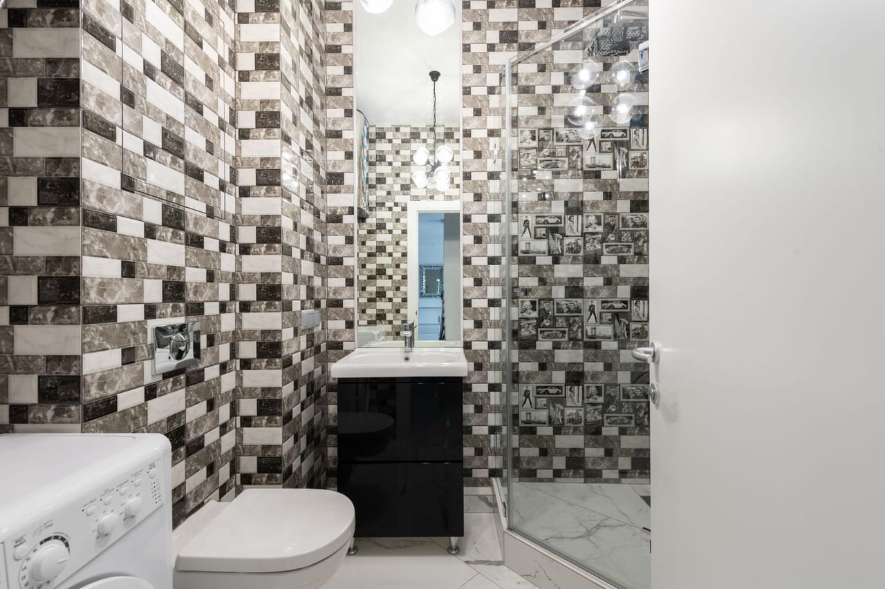 Plumber Rockford IL: Restroom interior with toilet and washing machine near sink