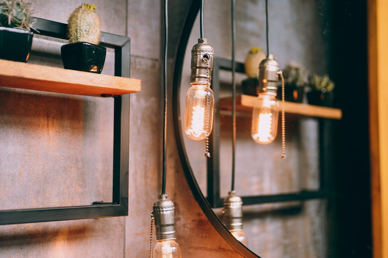 Plumber Round Rock TX: A bathroom with a round mirror and pendant lights