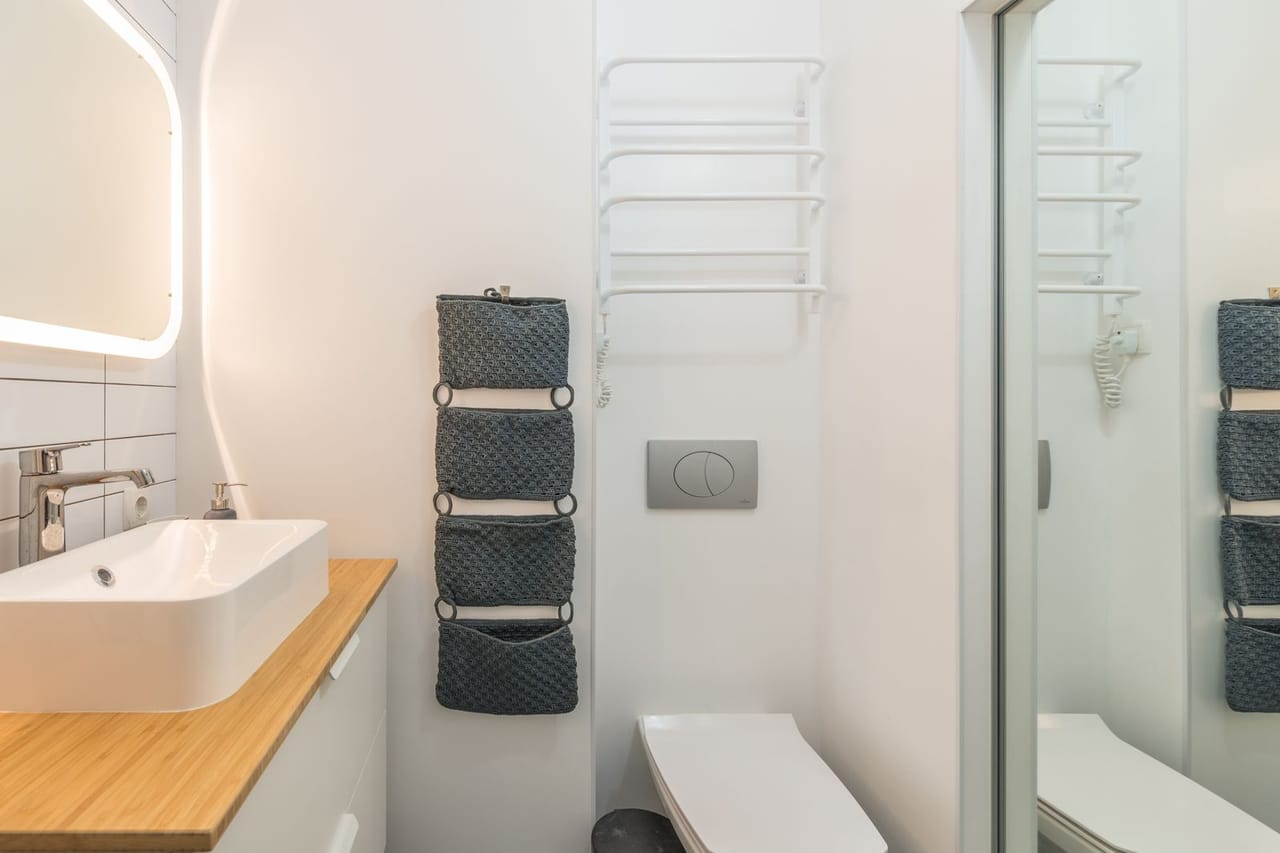 Plumber San Bernardino CA: Toilet and sink in modern light bathroom