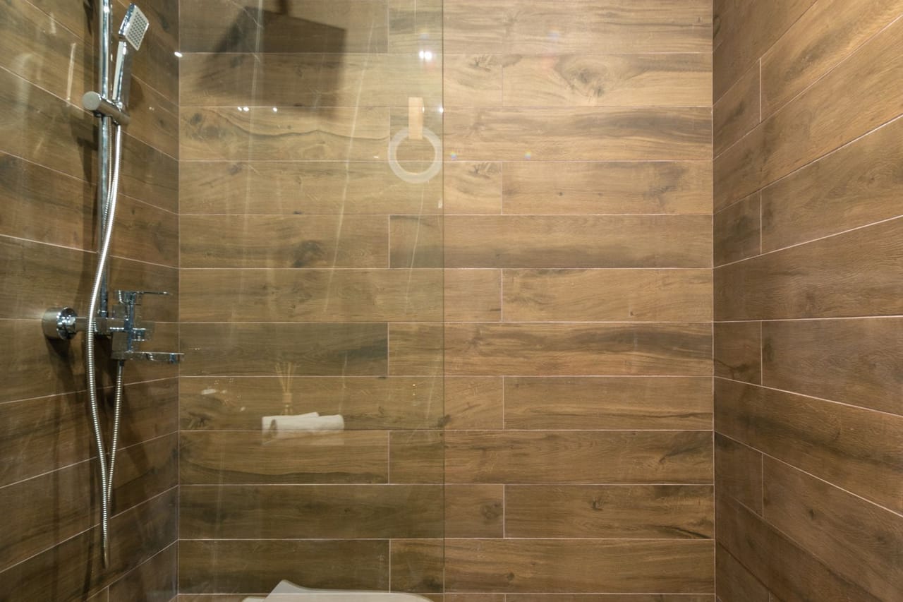 Plumber Sioux Falls SD: Clear glass shower stall with stainless steel shower head