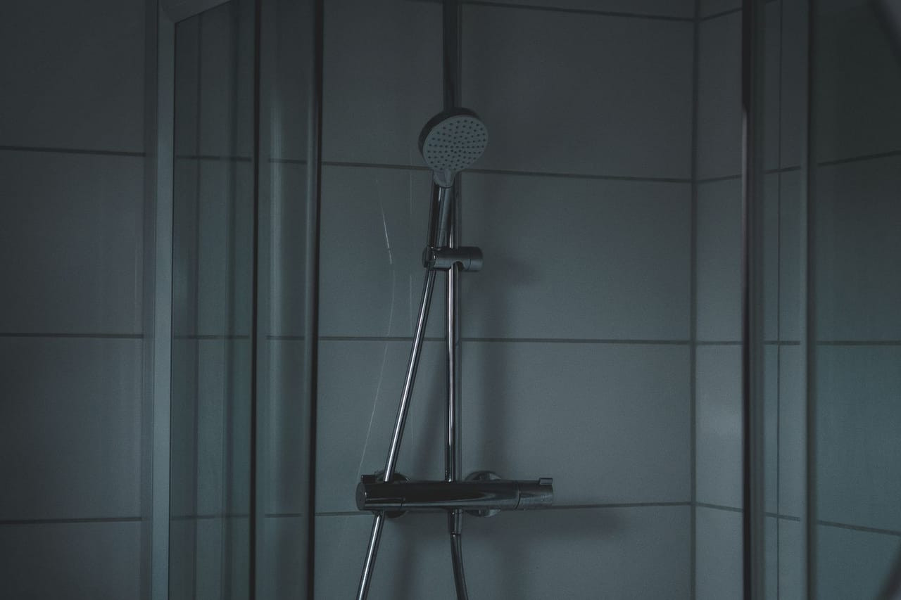 Plumber Springfield MO: Stainless steel shower head on white tiled wall