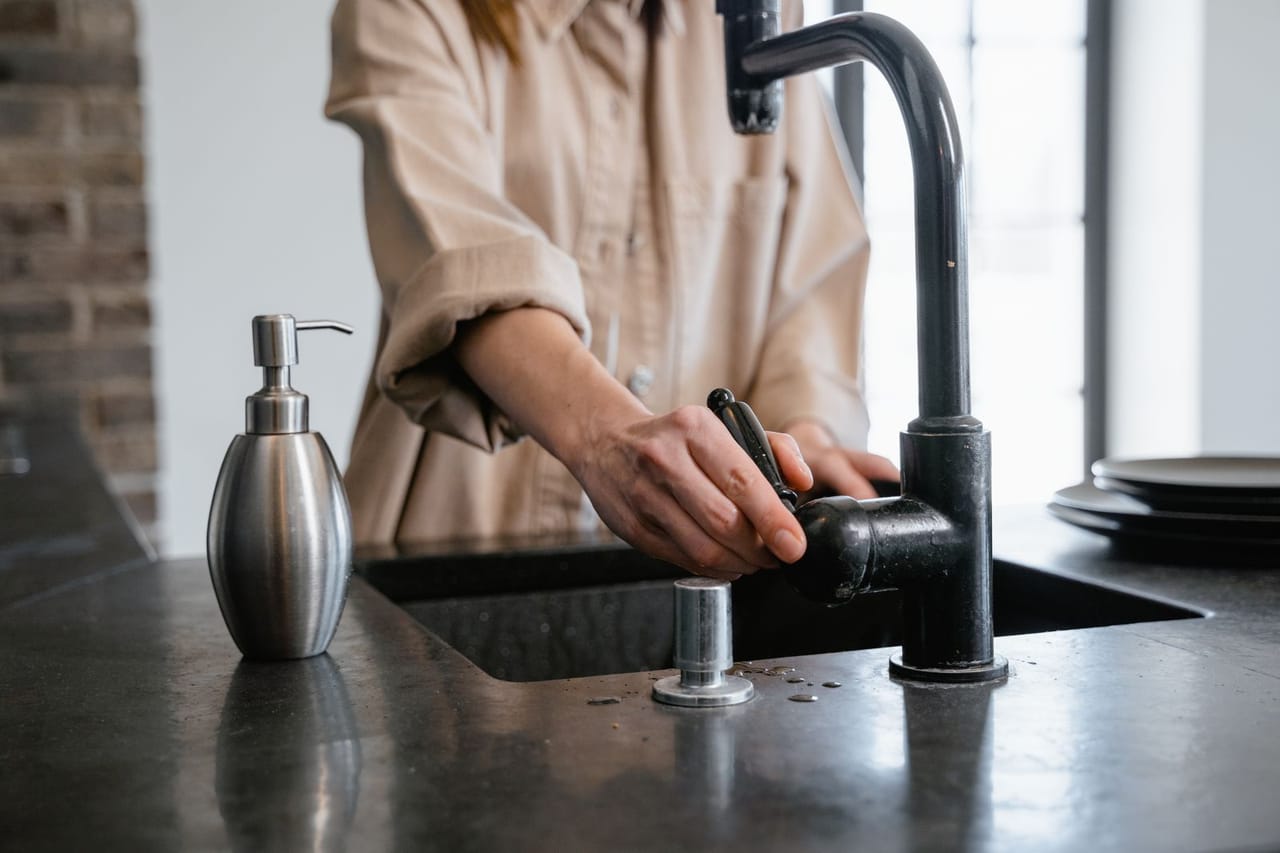 Plumber Stockton CA: Close up photo of person using faucet