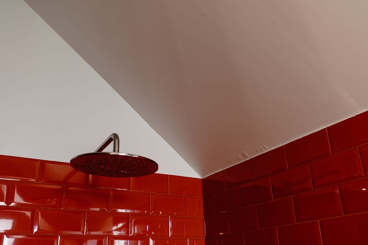 Plumber Terre Haute IN: A round shower head on the red brick wall
