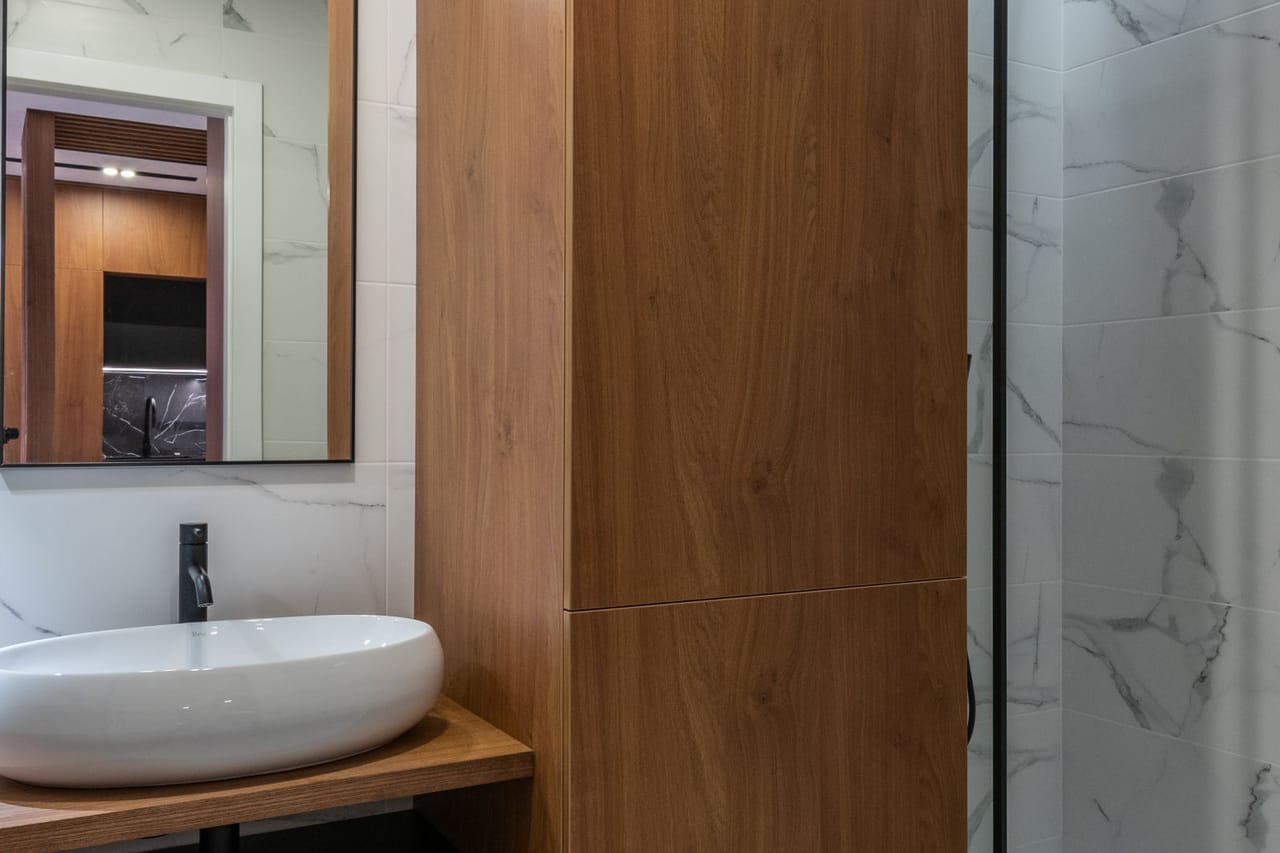 Plumber Warren OH: Wooden details of modern bathroom with sink and shower cabin