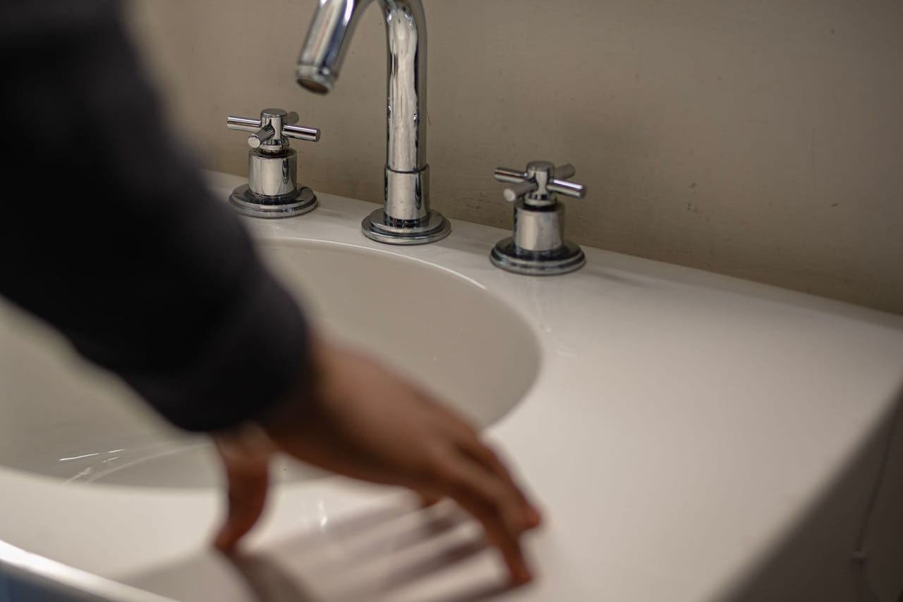 Plumber Watertown WI: A person in black sweater holding white ceramic sink