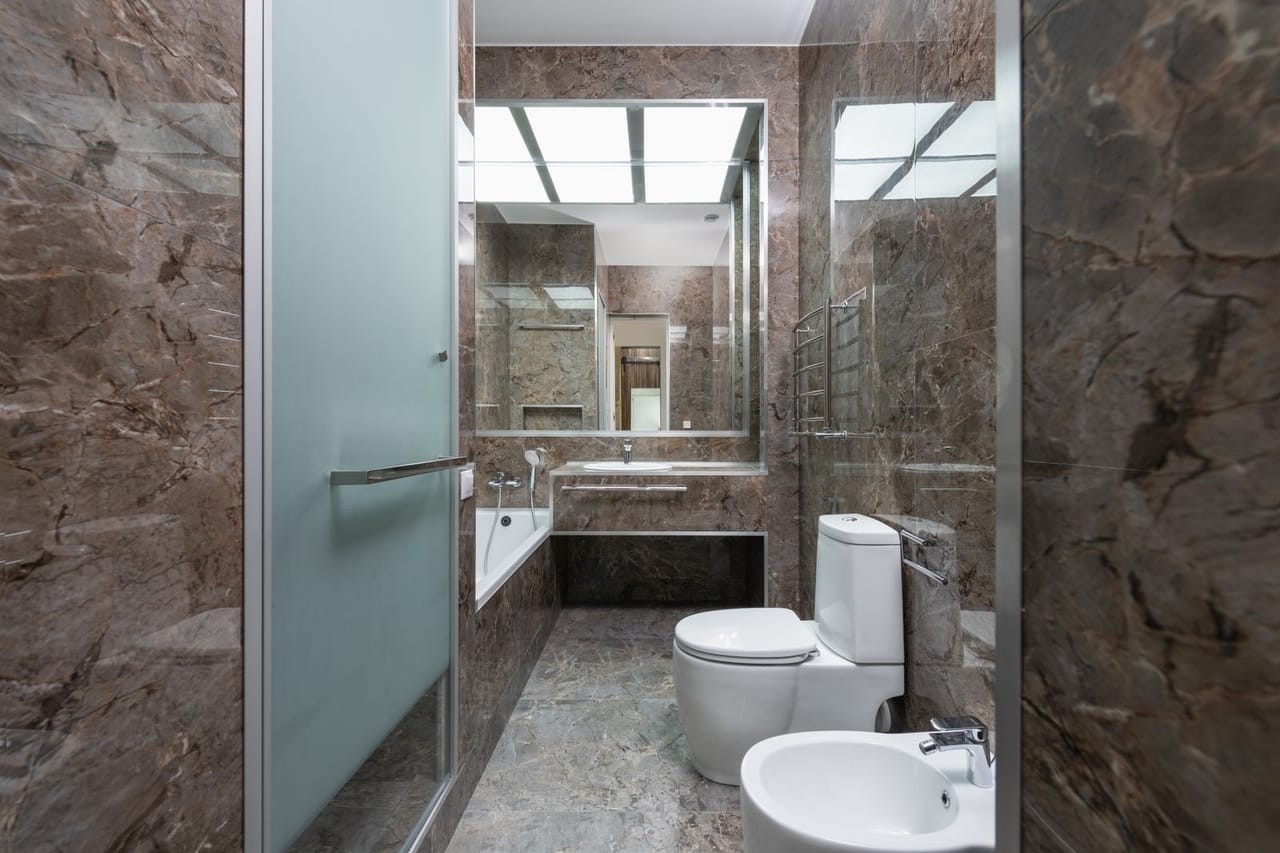 Plumber Winston Salem NC: White ceramic toilet bowl near the sink