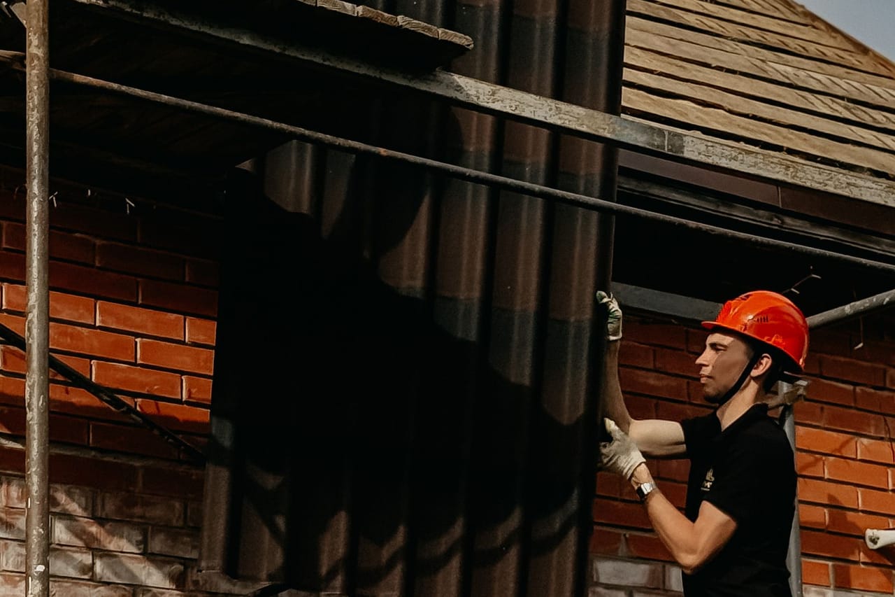 Roof repair Bethlehem PA: Construction workers installing roof panels on scaffold