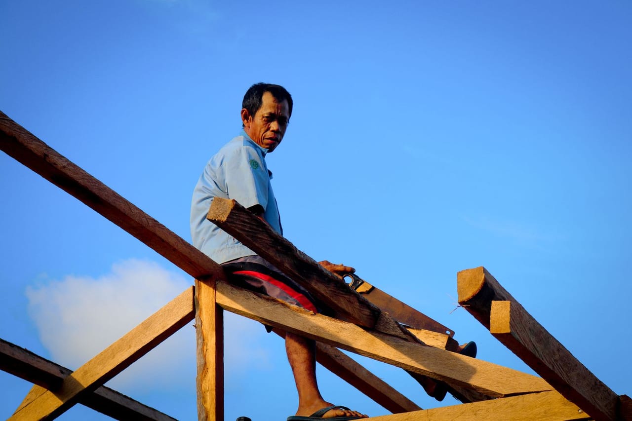 Roof repair Boise ID: Carpenter cutting a roof frame