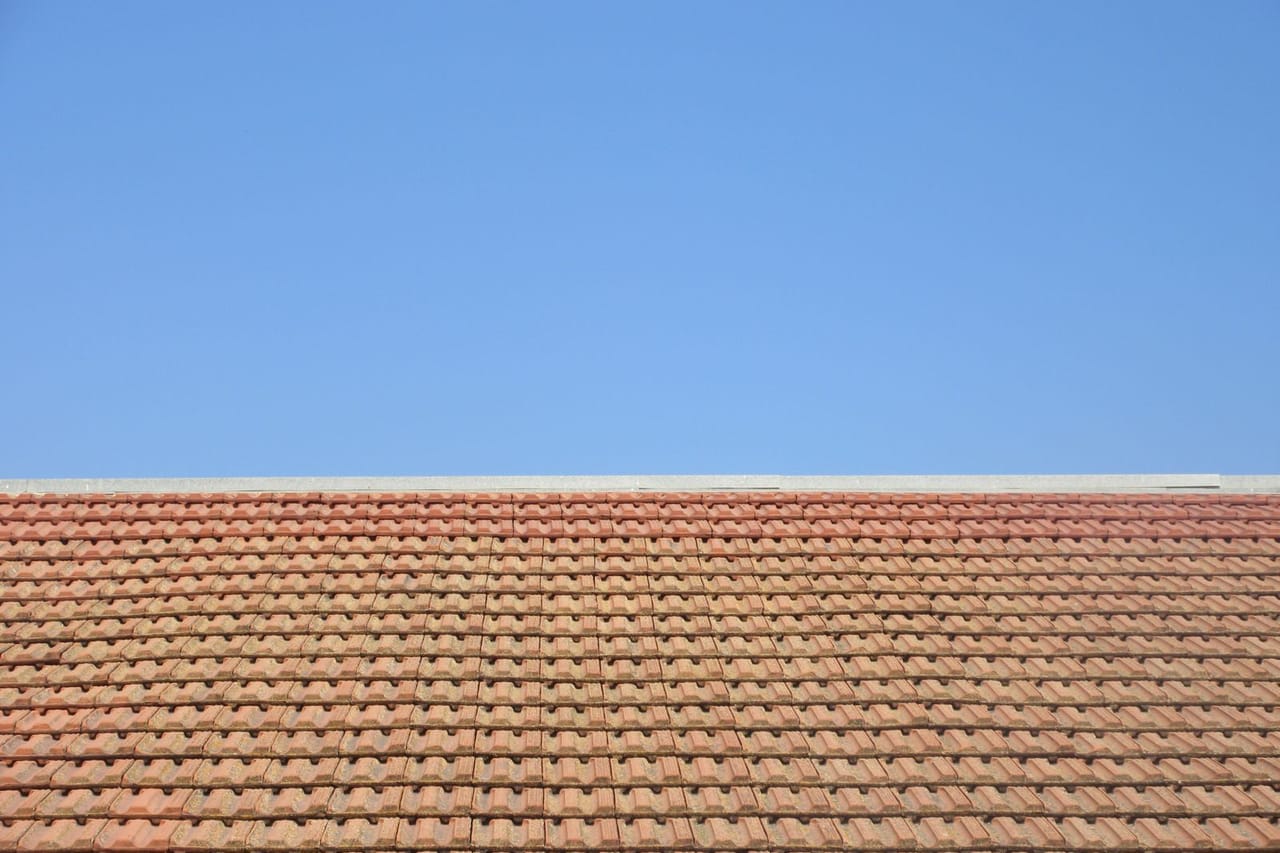 Roof repair Burlington VT: Terracotta roof under clear blue sky