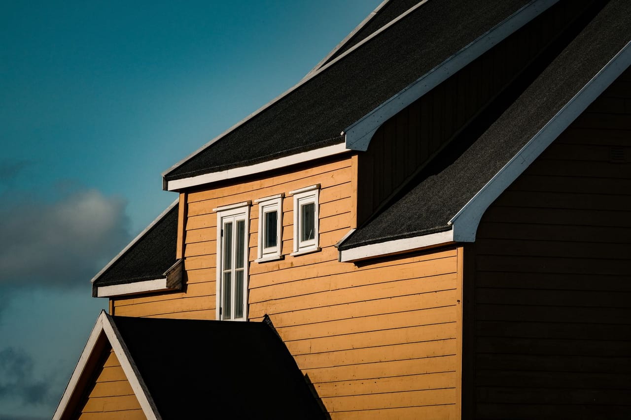 Roof repair Fortuna CA: Sunny yellow house with angular roof design