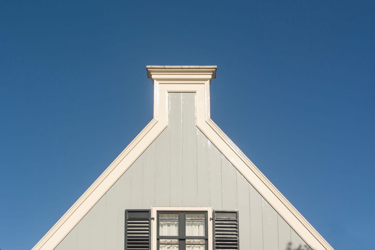 Roof repair Fremont CA: Gable roof of modern house against clear blue sky