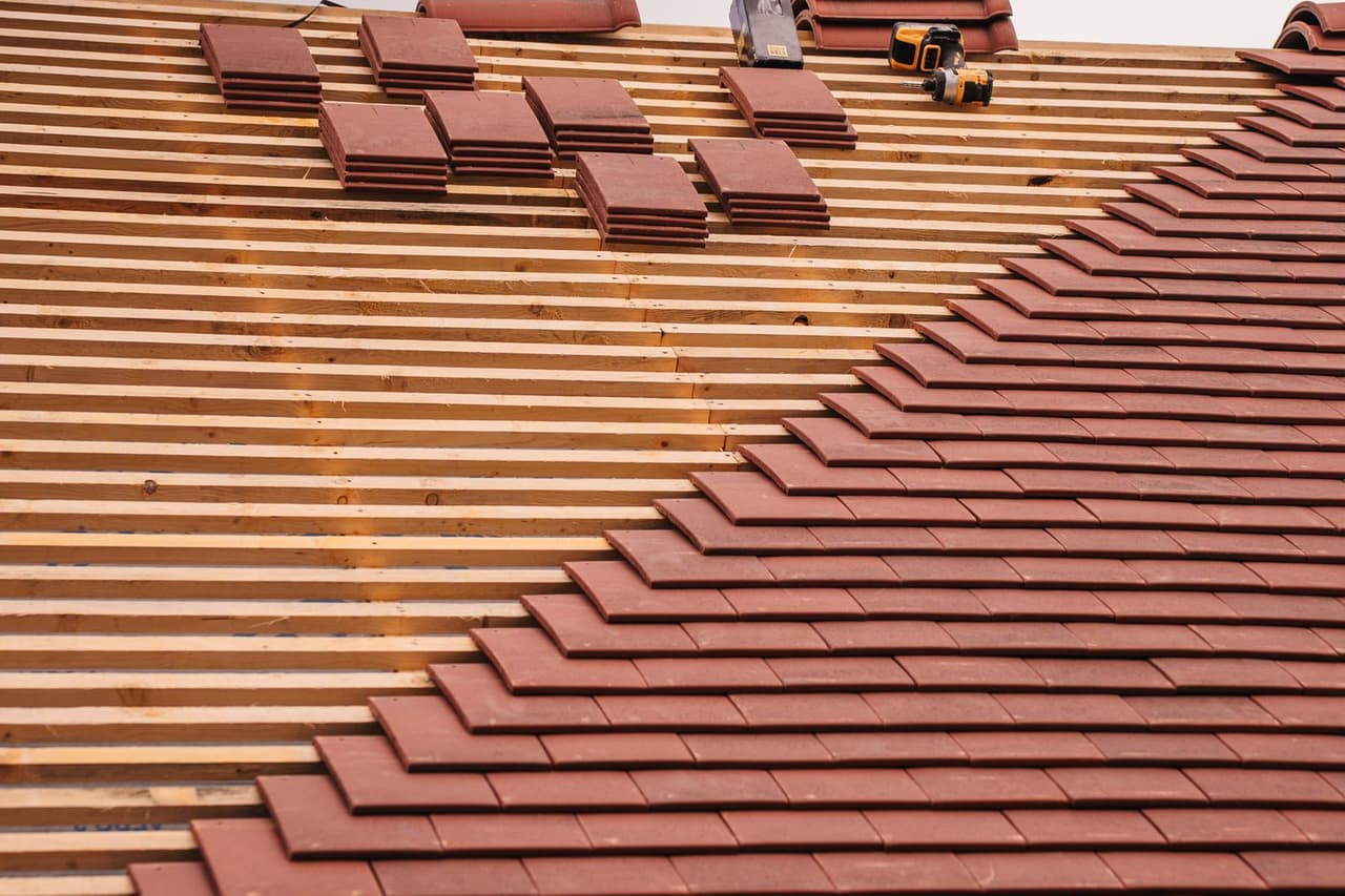 Roof repair Jacksonville FL: Roof installation with terracotta tiles in progress