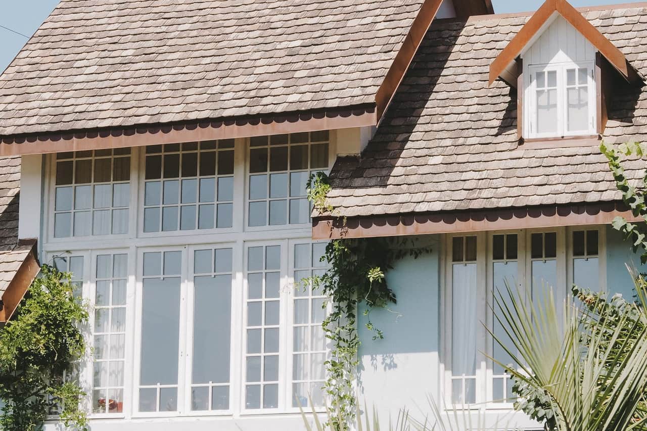 Roof repair Lakeland FL: Beautiful house with large windows and shingles roof