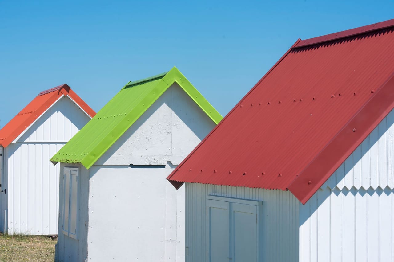 Roof repair Long Beach CA: Colorful beach huts with vibrant rooftops