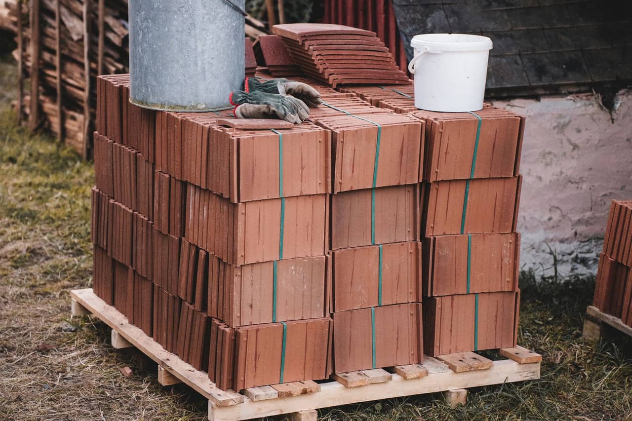 Roof repair Los Angeles CA: Stack of roof tiles with buckets outdoors
