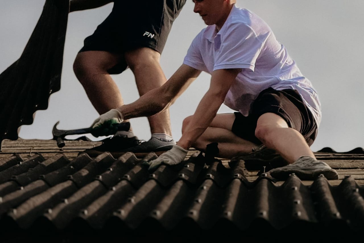 Roof repair Monterey CA: Roofing workers in action under clear sky