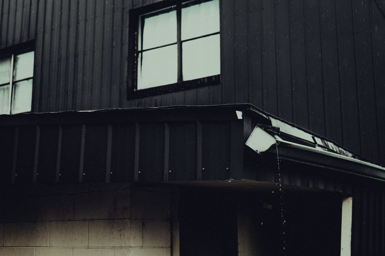 Roof repair Ponca City OK: Moody rain soaked building exterior scene
