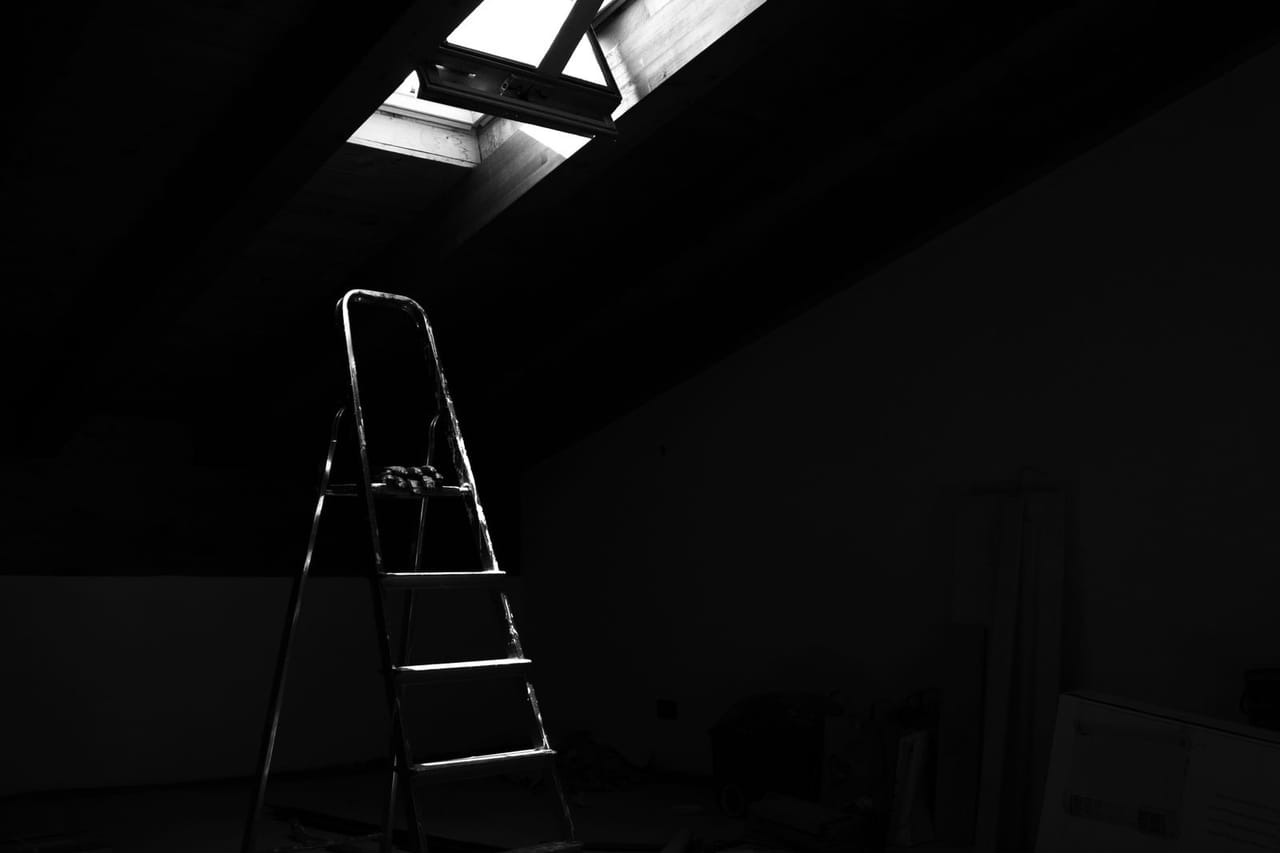 Roof repair Riverside CA: Grayscale photo of a ladder in an attic