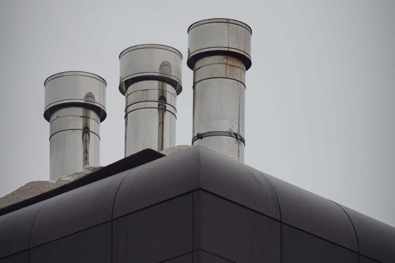 Roof repair Sumter SC: Black and white photo of metal chimneys