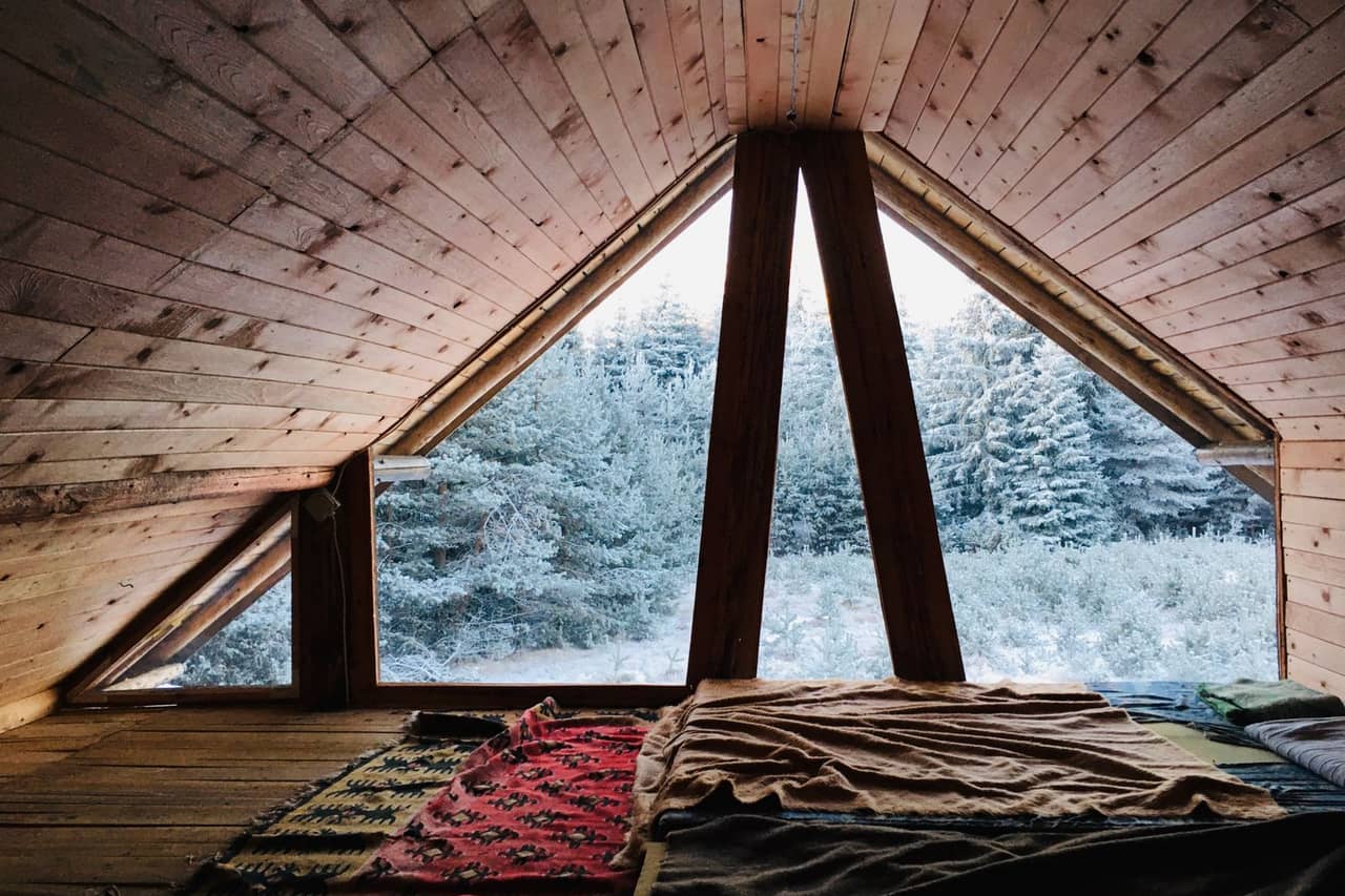 Roof repair Texarkana TX: A wooden attic with bed and blanket