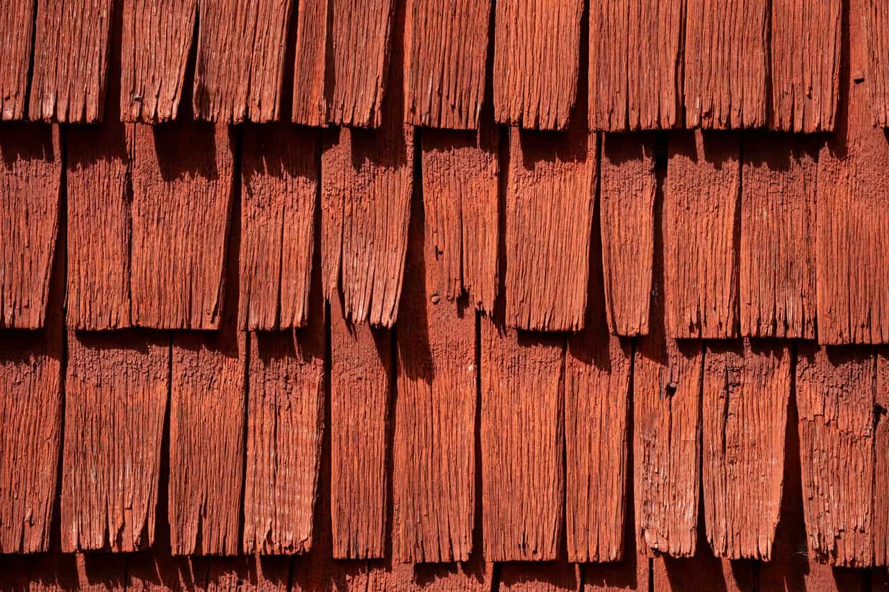 Roof repair Trenton NJ: Weathered red wooden shingles close up
