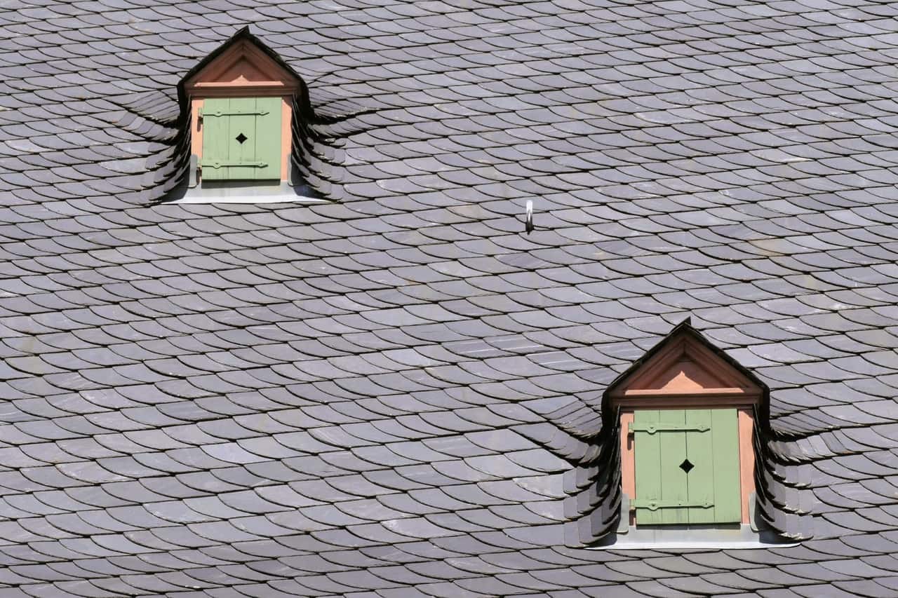 Roof repair Tulsa OK: Slate rooftop with green shuttered dormers