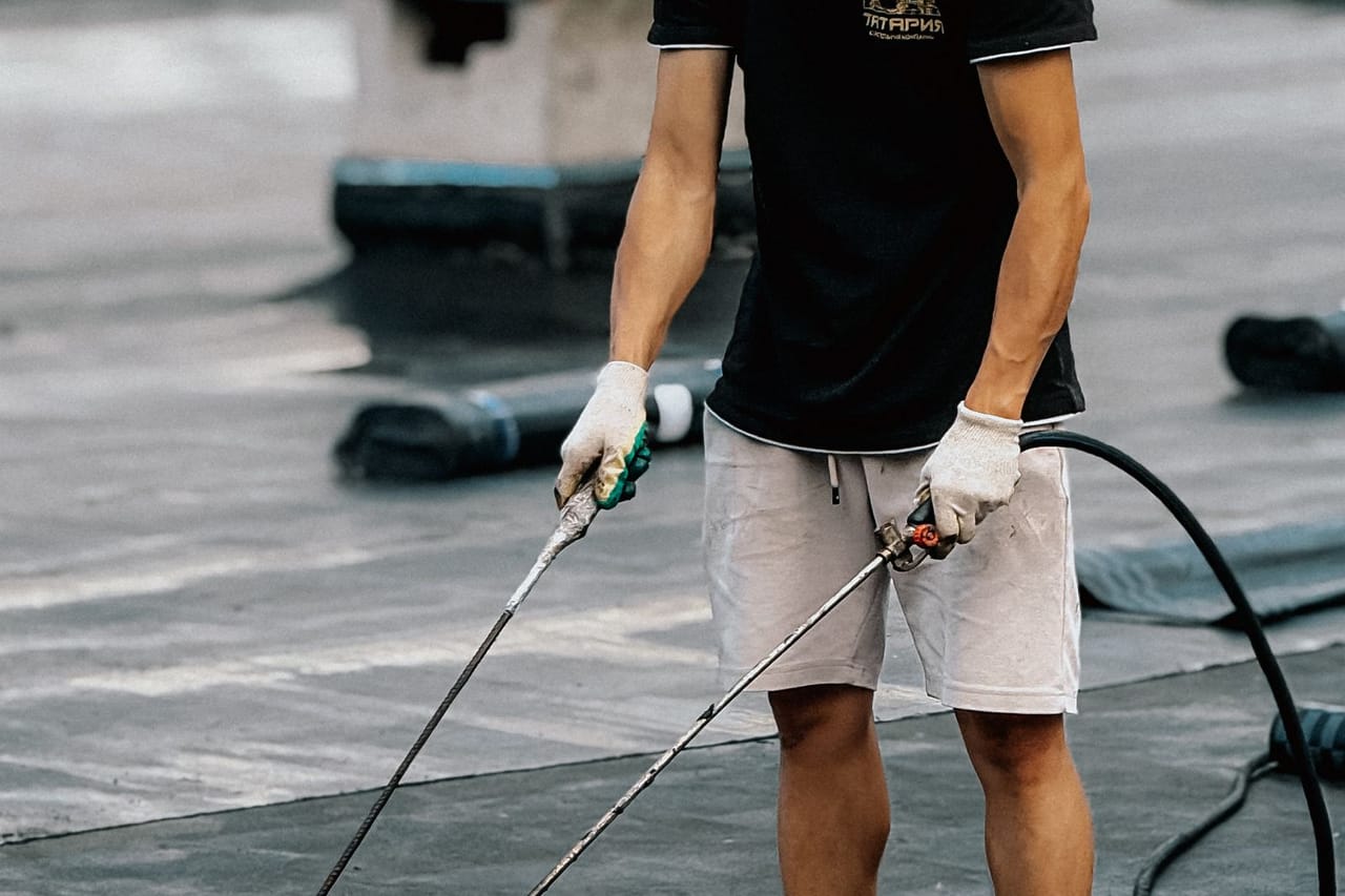 Roof repair Waco TX: Roofer applying waterproof membrane on rooftop