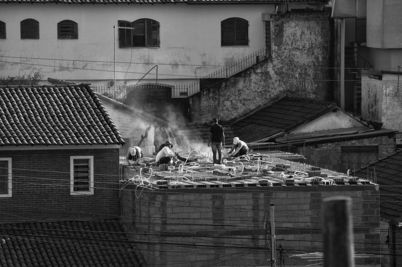 Roof repair Walnut Creek CA: Construction workers on urban rooftop
