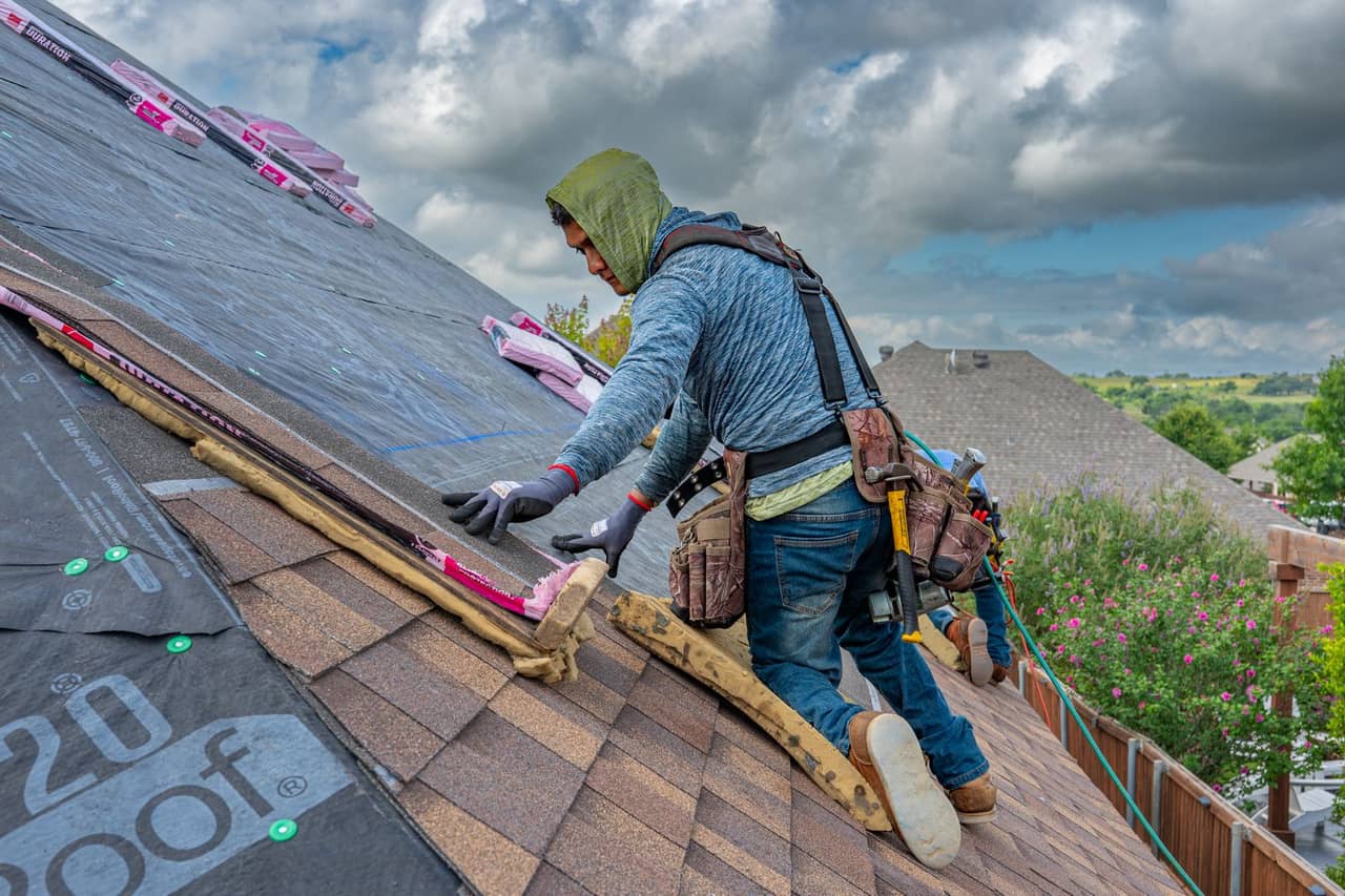 Roof repair Warren MI: Roofer installing shingles on a sunny day