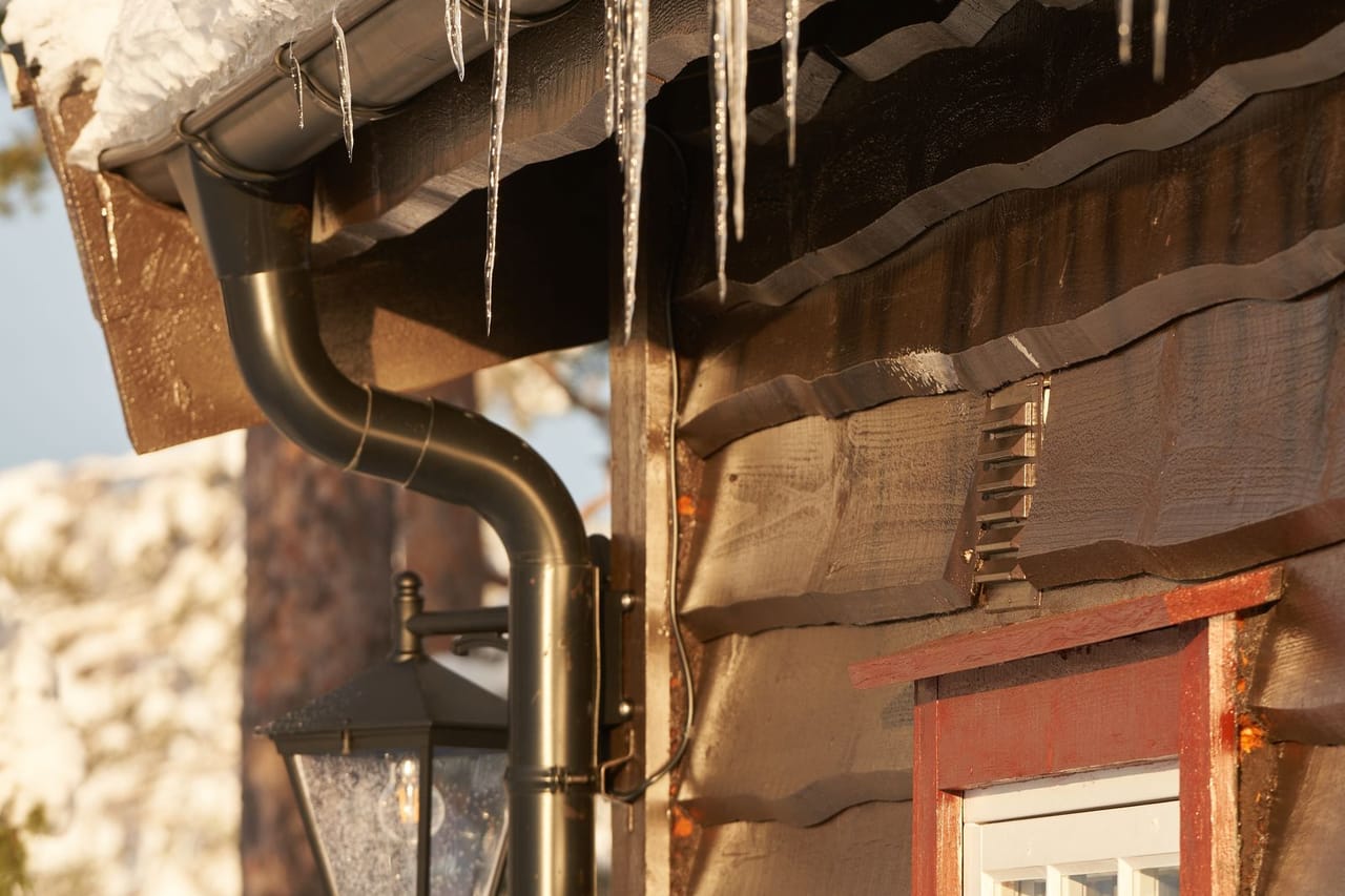 Roof repair Watsonville CA: Icicles hanging from a gutter