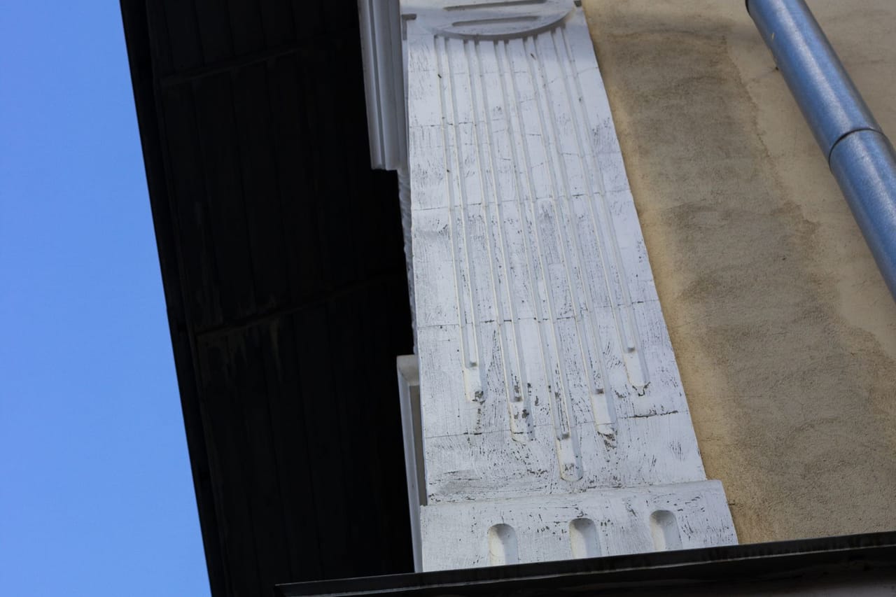 Roof repair West Allis WI: Drain pipe near the concrete wall of a building