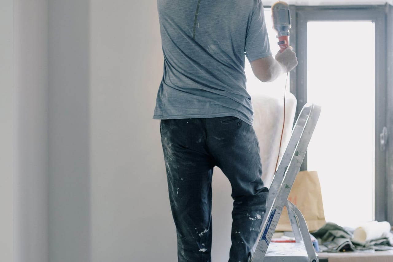 Roof repair Williamsport PA: Male builder with instrument in apartment