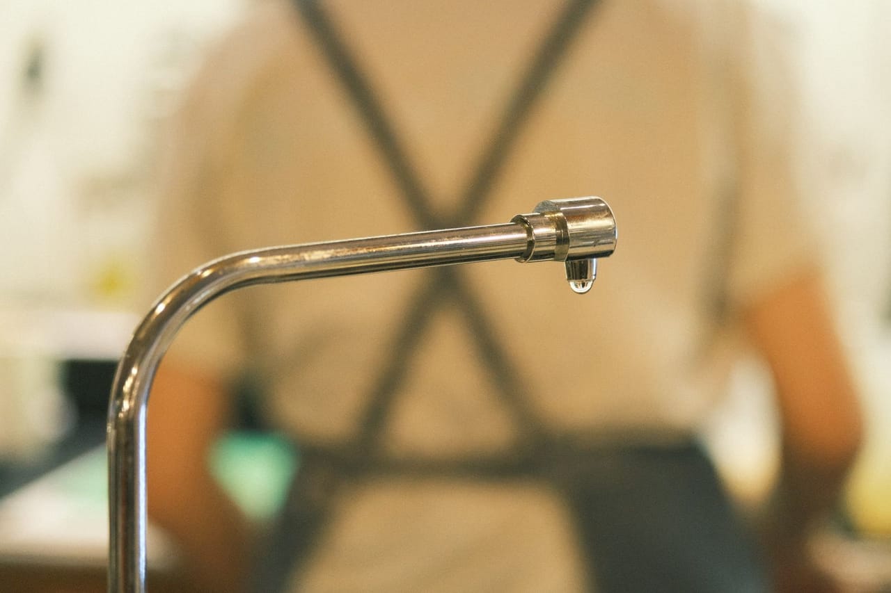 Water damage restoration Garland TX: Close up of a dripping faucet indoors