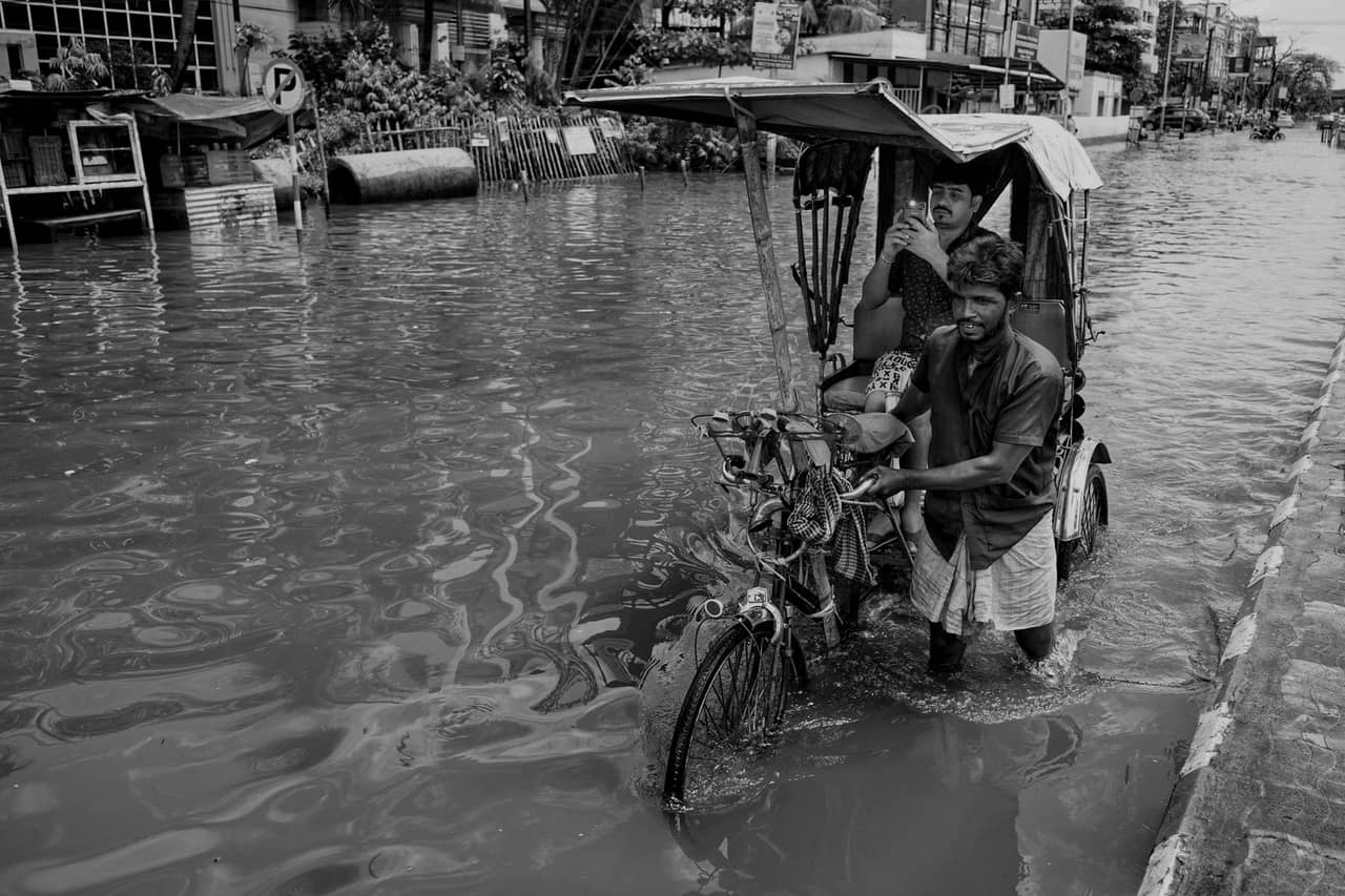 Water damage restoration Monterey CA: Men with rickshaw on street during flood