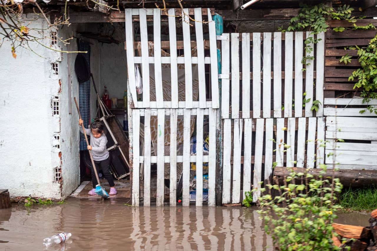 Water damage restoration Petaluma CA: Child cleaning flooded area