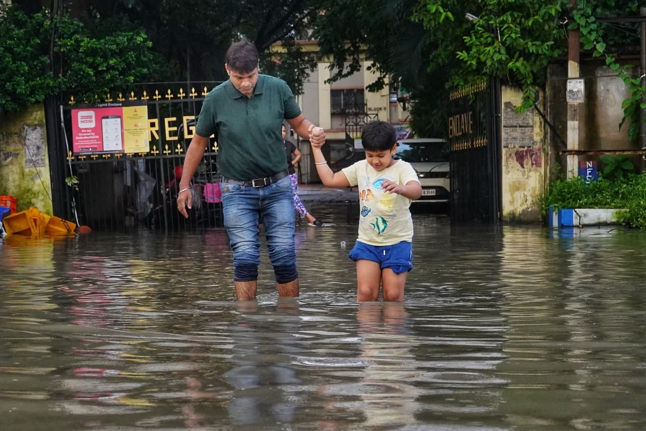 Water damage restoration in Phoenix: Father and son walking on a flooded street
