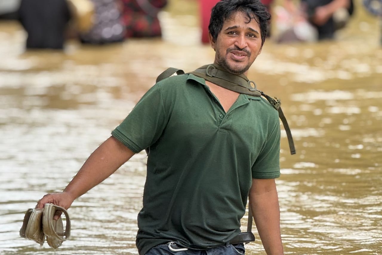 Water damage restoration Sierra Vista AZ: Man walking through floodwaters in green shirt